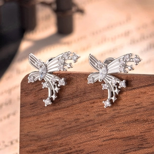 Silver butterfly stud earrings with sparkling diamonds on a vintage wooden surface