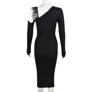 Detail of black ribbed knit dress featuring elegant shoulder feather fringe and asymmetry