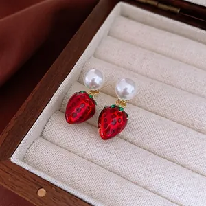 Sweet red strawberry drop earrings with pearls and gold accents in a wooden jewelry box