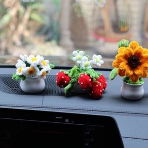 Detailed view of handmade chenille stem sunflower, strawberry, and daisy car dashboard decor
