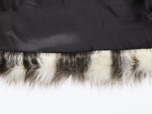 Macro detail of high-quality black fabric and two-tone faux fur trim on winter coat