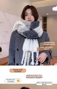 Detail of soft knit scarf featuring thick black white grey colorblock and long braided tassels