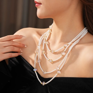 Gros plan d'un collier de perles multicouche avec cristaux et détails dorés
