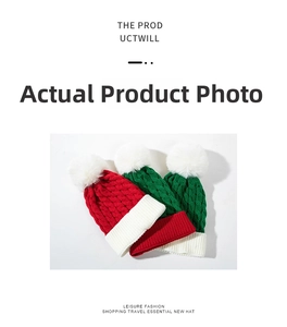 Close-up of thick knit Christmas hats with plush pom-poms in festive color combinations