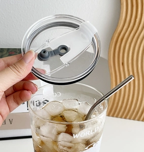 Detail of transparent straw lid with white flip top and grey silicone seal for coffee cups