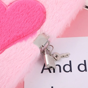 Detailed close-up of the soft pink plush texture and silver metal lock on the notebook