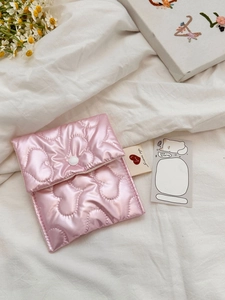 Detail of pink quilted heart sanitary bag with button closure and soft satin texture