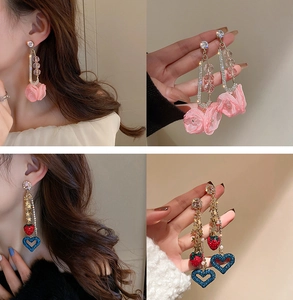 Detalle de los pendientes de borla con flores rosas y fresas mostrando el delicado pedrería