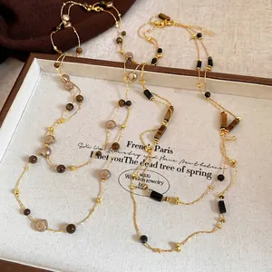Vintage tiger eye beaded long layering necklace with gold chains on a wooden tray