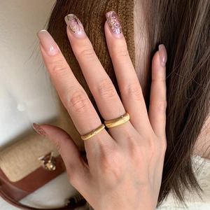 Brushed gold rings with sparkling zircon accents worn by model in vintage style