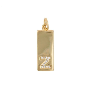 Macro detail of golden rectangular pendant featuring zircon letter Z and top loop