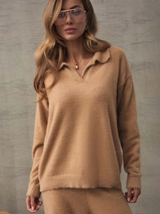 Detail of soft plush knitted polo collar sweater and trousers in camel color