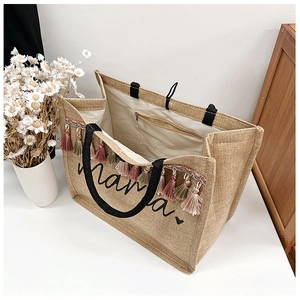 Detail view of large jute tote bag with Mama print, colorful tassels and zipper pocket