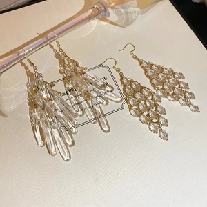 Detailed view of elegant gold tassel earrings with crystal teardrops and faceted beads