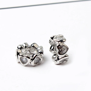 Detailed view of silver heart-shaped charms with sparkling clear zircon stones