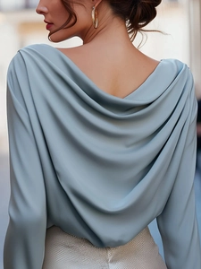 Detail of light blue satin top featuring an elegant backless draped cowl neck design