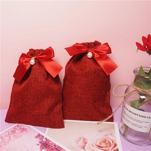 Elegante sacchetto regalo in lino bordeaux con fiocco rosso e perla decorativa
