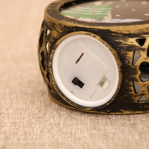 Detailed close-up of the vintage gold night light's bottom battery compartment and power switch