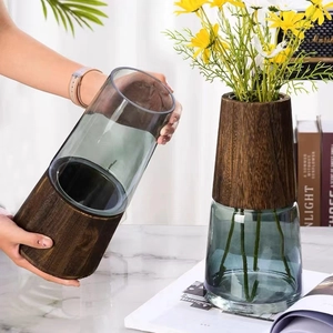 Modern deep green glass vase with dark wood base for long stem floral arrangements