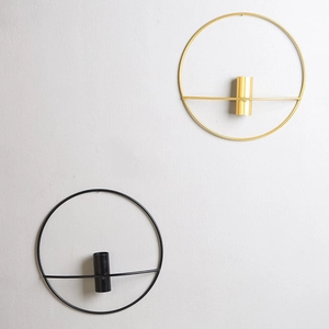 Modern circular metal wall candle holders in gold and black with minimalist geometric design