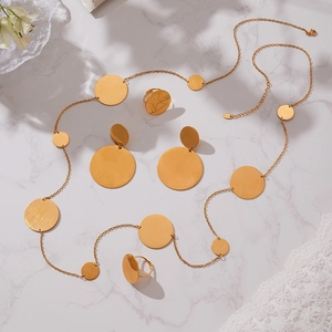 18k gold plated stainless steel jewelry set with circular pendants on marble surface