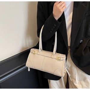 Chic off-white PU leather tote bag held by a model in a minimalist professional setting