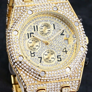 Detailed close-up of golden chronograph watch with iced-out diamonds and octagonal bezel