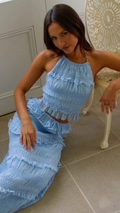 Detail of light blue halter crop top with pleated texture and layered ruffle maxi skirt