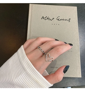 Detail of s925 silver hollow heart ring on a finger with a vintage artistic feel