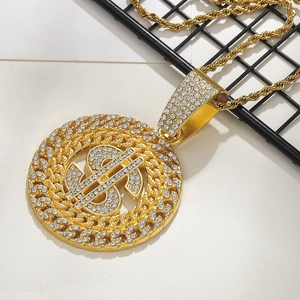 Gros plan d'un pendentif signe dollar doré orné de strass brillants sur une chaîne torsadée