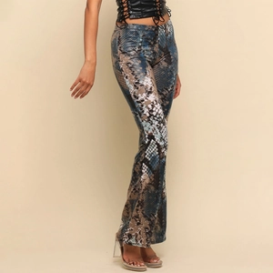 Detail view of high-waisted flared pants featuring exotic blue and brown snake skin print