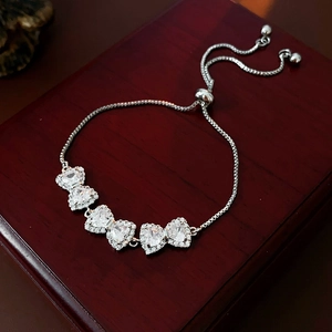 Dettaglio ravvicinato di un bracciale a fiocco argento con zircone a cuore su cofanetto