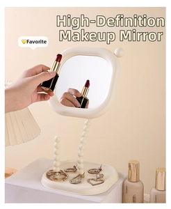 Close-up detail of cream pearl makeup mirror with rotatable head and jewelry storage tray