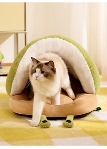 Close-up of semi-enclosed avocado-shaped warm cat bed with a fluffy Ragdoll cat inside