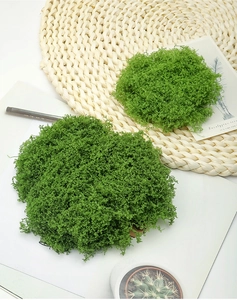 Detail view of fluffy green artificial moss clumps on a woven mat for DIY decor