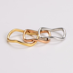 Three-piece set of polished wavy stainless steel rings in gold, rose gold, and silver