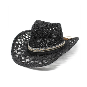 Détail d'un chapeau de soleil noir tressé ajouré avec bande bohème et décor de franges