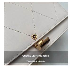 Detail of cream quilted leather bag featuring a high-quality gold metal twist lock