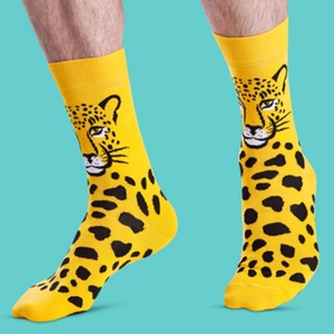 Detail of yellow cotton socks with black leopard print pattern on a green background