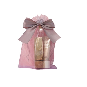 Pink organza gift bag with pearl bow featuring cosmetics inside for packaging