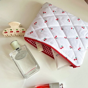 Quilted white cosmetic bag with red cherry embroidery and zipper closure for travel