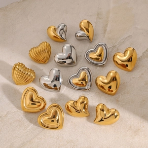 Assorted heart-shaped stainless steel earrings in gold and silver finishes on stone