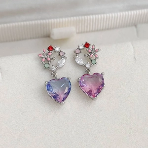 Detailed view of heart-shaped gemstone earrings with floral zircon studs and gradient crystals