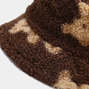 Close-up of thick beige and dark brown sherpa wool texture on a cozy bucket hat