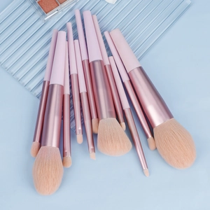 Kit de 13 pinceaux de maquillage rose et or rose avec poils synthétiques sur bleu