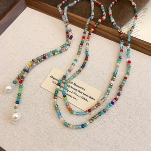 Close-up of bohemian colorful crystal beaded necklace with large white pearl pendants