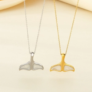 Détail de pendentifs queue de baleine en argent et or avec incrustation de nacre