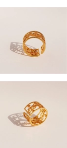 Close-up of vintage hollow floral pattern gold ring with intricate beaded edges