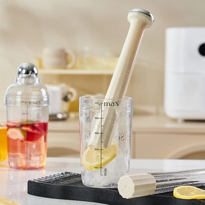 500ml graduated measuring cup with cream textured cocktail muddler in a kitchen setting