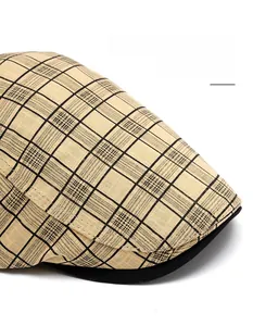 Close-up of the vintage plaid newsboy cap showing the curved brim and cotton texture